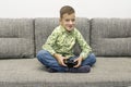 Leisure, children, technology and people concept - smiling boy with joystick playing video game at home Royalty Free Stock Photo