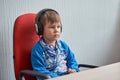 Leisure, education, children, technology and people concept - boy with computer and headphones at office