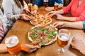 friends eating pizza with beer at restaurant Royalty Free Stock Photo