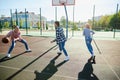 Group of friends bonding outdoors to play street basketball. Teens wearing casual style clothes. Kids look happy Royalty Free Stock Photo