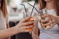 Leisure, holidays, eating, people and food concept - happy friends having dinner at summer garden party and clinking drinks