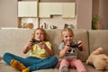 Leisure moments. Excited kids, little boy and girl looking focused while playing video games using joystick or Royalty Free Stock Photo