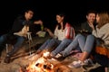 Friends having picnic at camp fire on beach Royalty Free Stock Photo