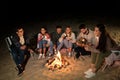 Friends roasting marshmallow on camp fire on beach Royalty Free Stock Photo