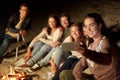 Happy friends taking selfie at camp fire on beach Royalty Free Stock Photo