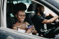 Leisure, road trip, travel, family and people concept - African happy man and woman driving in car with coffee Royalty Free Stock Photo