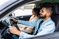 leisure, road trip, travel, family and people concept. Young happy indian man and woman driving in car Royalty Free Stock Photo