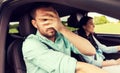 Woman driving car and man covering face with palm Royalty Free Stock Photo