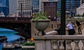 Leisure seeking businessmen lean on the ledge of Upper Wacker Drive as they look down at the Chicago River