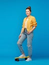 Red haired teenage girl with short skateboard Royalty Free Stock Photo