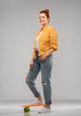 Red haired teenage girl with short skateboard Royalty Free Stock Photo