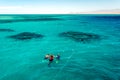 Leisure and sports, several people snorkeling in the blue sea