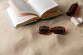 book, sunglasses and sunscreen on beach sand Royalty Free Stock Photo