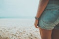 Young tanned woman standing relax on a tropical beach. Blue sea in the background. Royalty Free Stock Photo