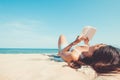 Young woman lying on a tropical beach, relax with book. Royalty Free Stock Photo