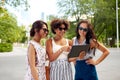 Women with tablet pc on street in summer