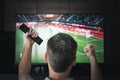 leisure, technology, sport, entertainment and people concept. man with remote control watching football or soccer game Royalty Free Stock Photo