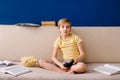 Leisure time, children, technology and people concept - little blonde boy with gamepad playing video game at home Royalty Free Stock Photo