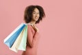 Leisure time and fun shopping. Happy millennial african american woman holds colored shopping bags