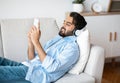 Leisure Time. Handsome Eastern Man With Smartphone Listening Music In Wireless Headphones Royalty Free Stock Photo