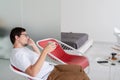 Man sitting in a chair watching tv holding tea cup and phone Royalty Free Stock Photo