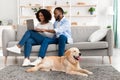 Black couple at home using laptop sitting with labrador Royalty Free Stock Photo