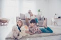 Leisure together. Happy family of four is enjoying at home, small kids are playing with toys, parents are on the sofa, hugging Royalty Free Stock Photo