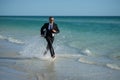 Leisure weekend and remote freelance work. Crazy comic business man in suit run on sea. Funny businessman with laptop Royalty Free Stock Photo