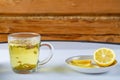 Lemgrass tea in a cup next to a lemon and sweets on a napkin on the table. Royalty Free Stock Photo