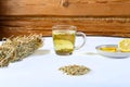 Lemgrass tea in a cup next to a lemon and sweets on a napkin on the table. Royalty Free Stock Photo