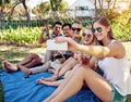 Lemme get one with all of us. a young group of friends taking selfies while enjoying a few drinks outside in the summer