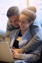 Lemme see that. an affectionate young couple surfing the net while relaxing on the sofa at home.