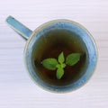 Lemon balm in cup of herbal drink on white wooden table Royalty Free Stock Photo