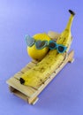 Lemon and banana with sunglasses resting on the wooden beach bed. Summer vacation concept Royalty Free Stock Photo