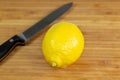 Lemon being sliced in half on a cutting board on a kitchen table Royalty Free Stock Photo