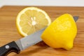 Lemon being sliced in half on a cutting board on a kitchen table Royalty Free Stock Photo