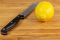 Lemon being sliced in half on a cutting board on a kitchen table Royalty Free Stock Photo