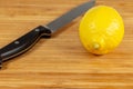 Lemon being sliced in half on a cutting board on a kitchen table Royalty Free Stock Photo