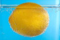 Lemon in Bubbly Water on blue background Royalty Free Stock Photo