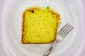 Lemon cake with icing. Detail of slice of lemon cake with icing and lemon zest on plate with fork in top view.