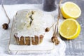 Lemon cake with poppy seeds, covered with glaze on a light background.