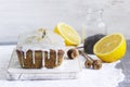 Lemon cake with poppy seeds, covered with glaze on a light background.