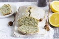 Lemon cake with poppy seeds, covered with glaze on a light background.