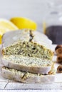 Lemon cake with poppy seeds, covered with glaze on a light background.