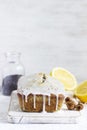 Lemon cake with poppy seeds, covered with glaze on a light background.