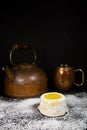 Lemon cake with powdered sugar on dark background with copper tea pot and mug Royalty Free Stock Photo