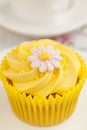 Lemon cupcake with butter cream swirl and fondant flower decoration Royalty Free Stock Photo