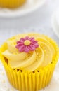 Lemon cupcake with butter cream swirl and fondant flower decoration Royalty Free Stock Photo