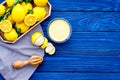 Lemon curd. Sweet cream for desserts near lemons in tray on blue wooden background top view copy space Royalty Free Stock Photo