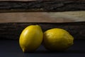Lemon on a dark background. Two lemons on a wooden background